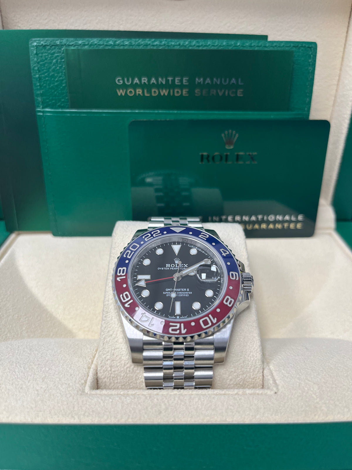 Rolex GMT watch featuring "Pepsi" (Blue top, Red Bottom)Bezel and a Black Dial.